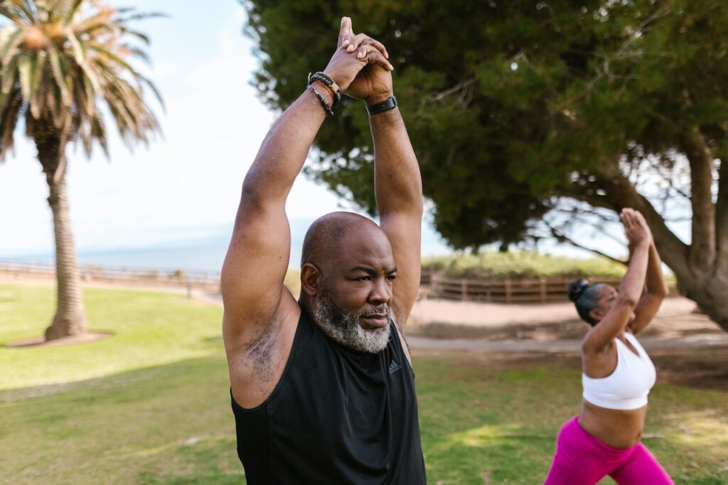 Photo by RODNAE Productions: https://www.pexels.com/photo/an-elderly-man-in-black-tank-top-raising-his-hands-together-8172941/